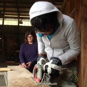 Tiny house workshop participants at Casa Pequena with a circular saw.